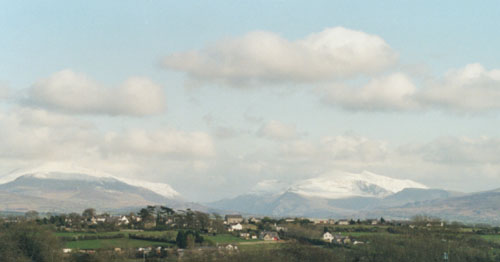 A fine afternoon on 14 April 2000 in North Wales. Snow on Snowdon (right) and Glyders (left), between is Llanberis Pass, view from Gaerwen towards Llanddaniel Fab, Anglesey. Photo: © D. Perkins.