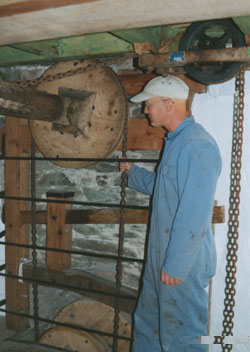 The assistant miller 'Will' demonstrating the sack hoist at Melin Llynnon. Photo: © 2000 D. Perkins.