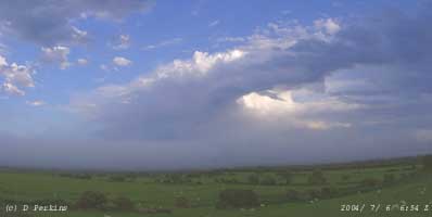 Cumulonimbus seen tracking NE, to the S of fog crossing the A55, on 7 June 2004. Click to see larger image. 