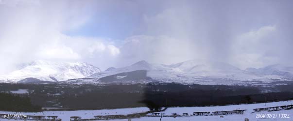 Snow showers driven by a strong NE'ly wind (left to right) move across the Snowdonia Mountains on the afternoon of 27 February 2004. From the left Carneddau, Nant Ffrancon Pass with the summit of Tryfan, Mynedd Perfedd and Elidir Fach with Glyders behind, Llanberis Pass and Snowdon on the right.