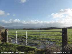 Wet field gateway in Llansadwrn on a sunny afternoon.