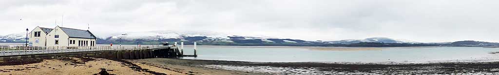 Low water at Beaumaris with snow on the mountains.